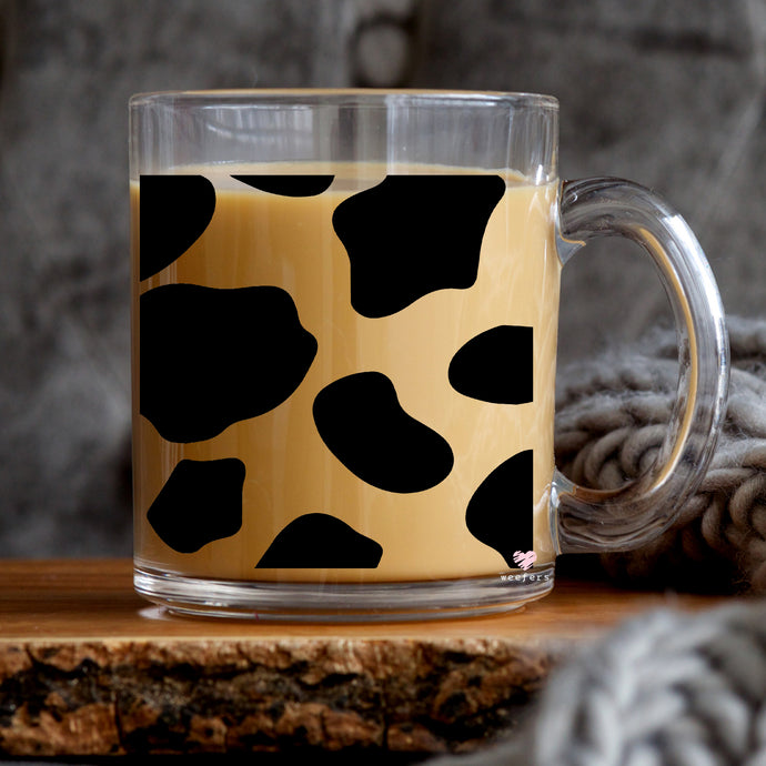 a glass mug with a cow print on it