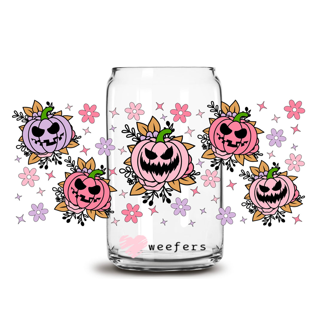 a glass jar filled with halloween pumpkins and flowers