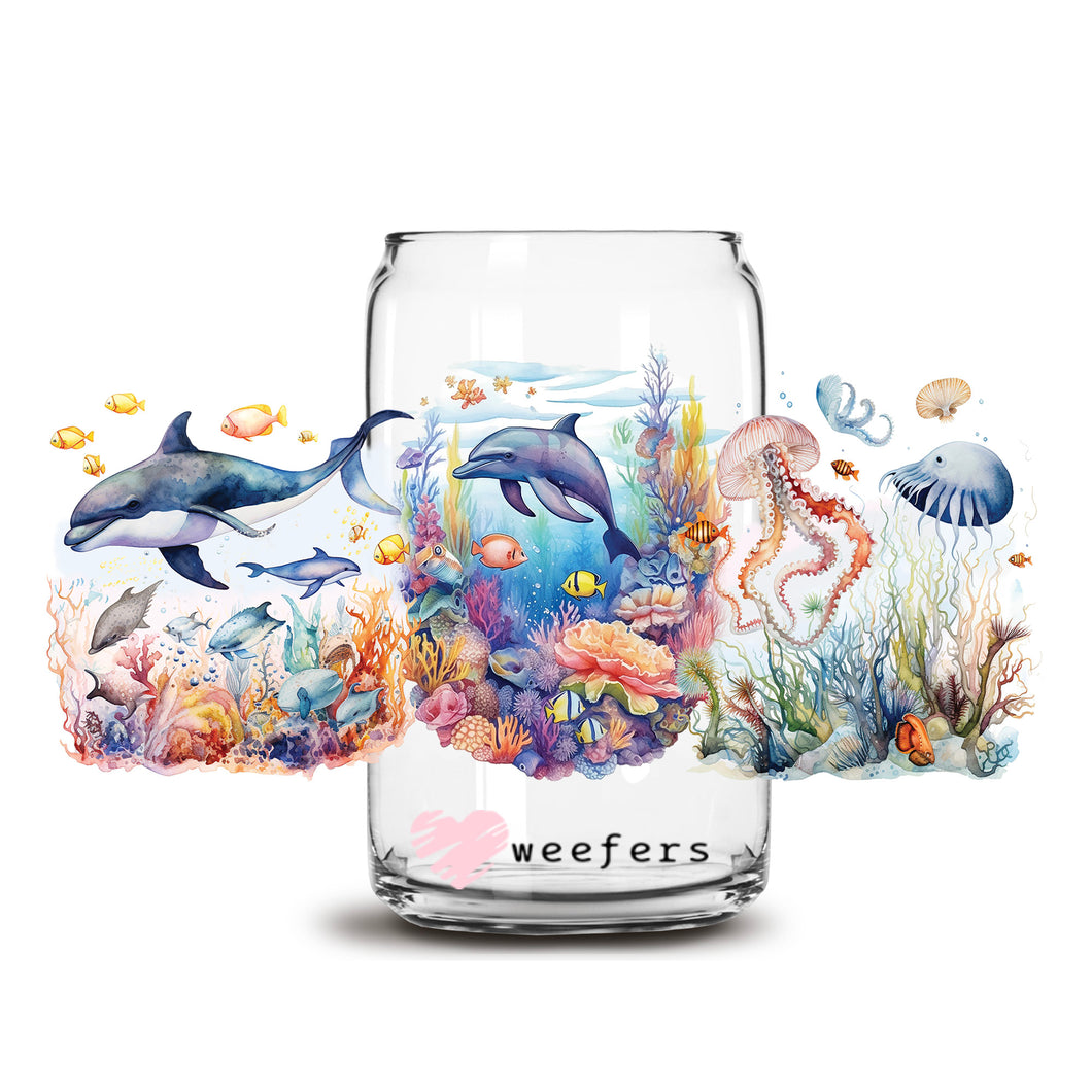 a glass jar with a painting of dolphins and other marine life