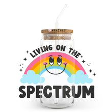 Load image into Gallery viewer, a jar with a straw in it that says living on the spectrum
