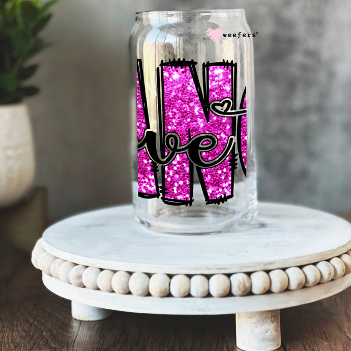 a glass jar with pink glitter in the shape of the letter n