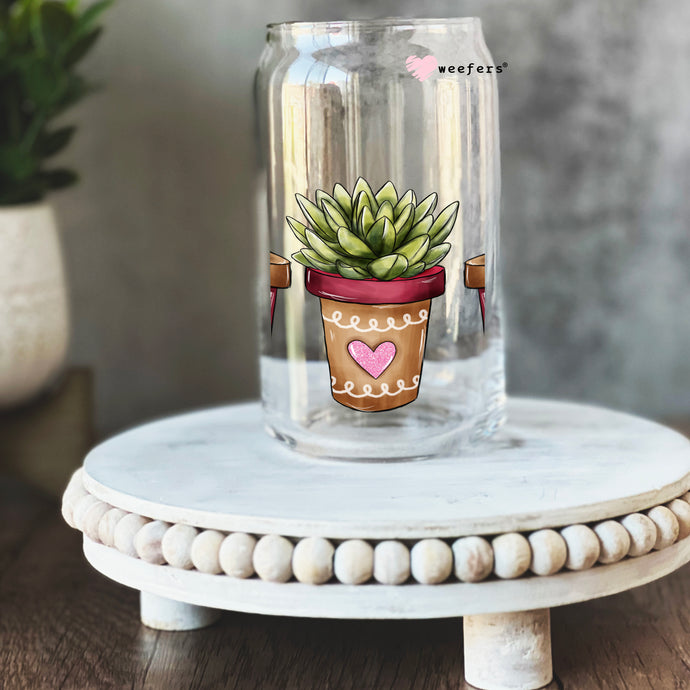 a glass jar with a picture of a potted plant on it