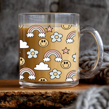 Load image into Gallery viewer, a glass mug with a pattern of smiley faces and rainbows

