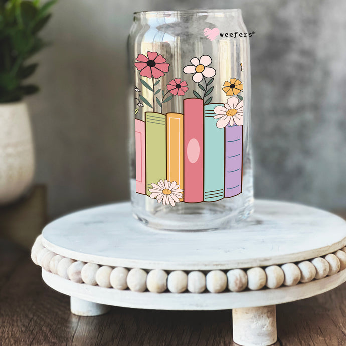 a glass jar with flowers and books painted on it