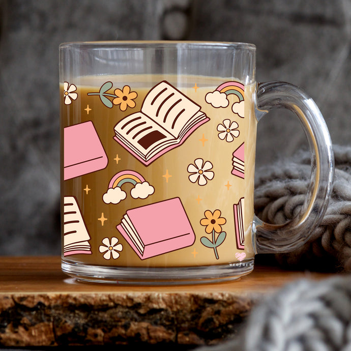 a glass mug with a book pattern on it