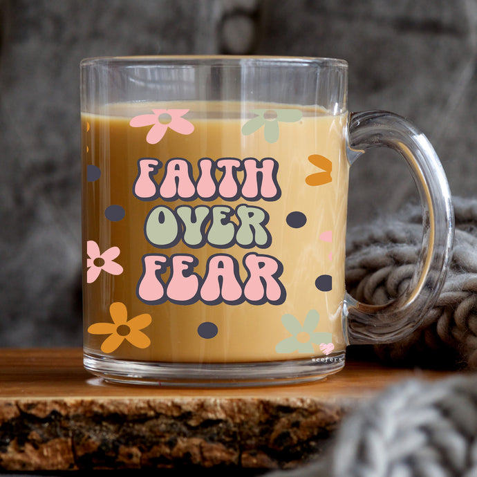 a glass mug with the words faith over fear printed on it