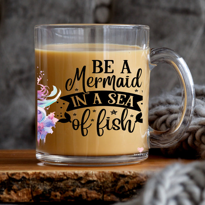 a glass mug that says be a mermaid in a sea of fish