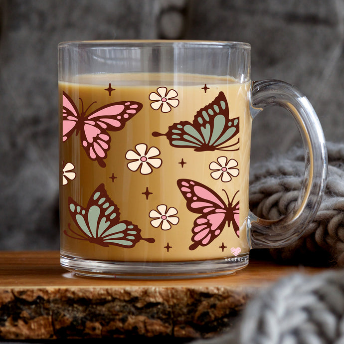 a glass mug with a pattern of butterflies on it