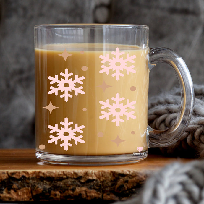 a cup of coffee with a pink snowflake pattern on it