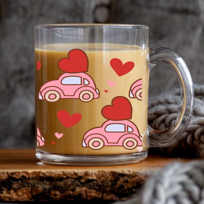a glass mug with a pink car and hearts on it