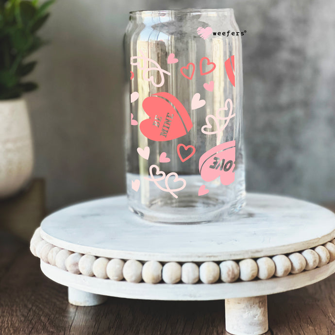a glass jar with hearts painted on it