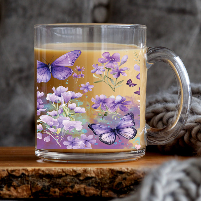 a glass mug with a butterfly design on it