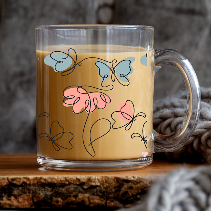 a glass mug with a painting of flowers on it
